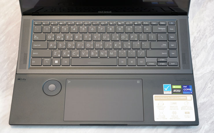 機身 C 面，上半部為孤島式鍵盤，下方有大面積的手托區與大尺寸的觸控板與方便創作者搭配創作應用使用的 ASUS Dial 旋鈕。