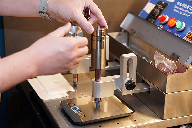 為了模擬日常使用手機的狀態，我們在磨耗機具上加上了砝碼增重。