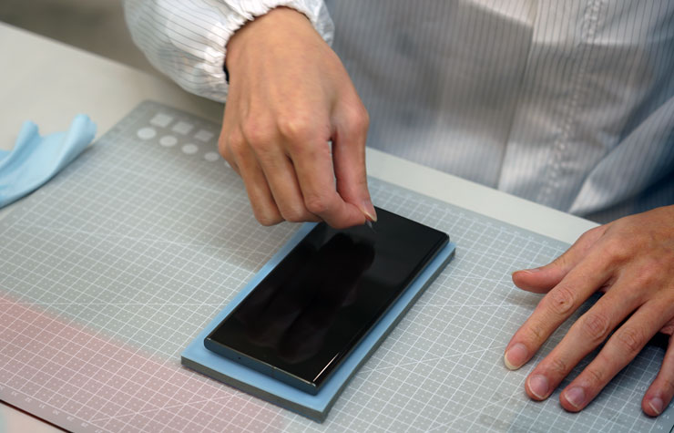 安裝保護貼之前，師傅再次仔細檢查手機螢幕是否還有灰塵細屑，真的很細心！