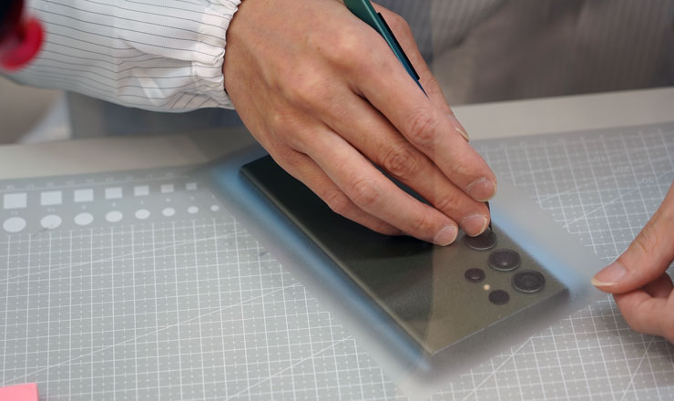 接下來就考驗師傅的刀工了，將鏡頭處的膜料小心割除。