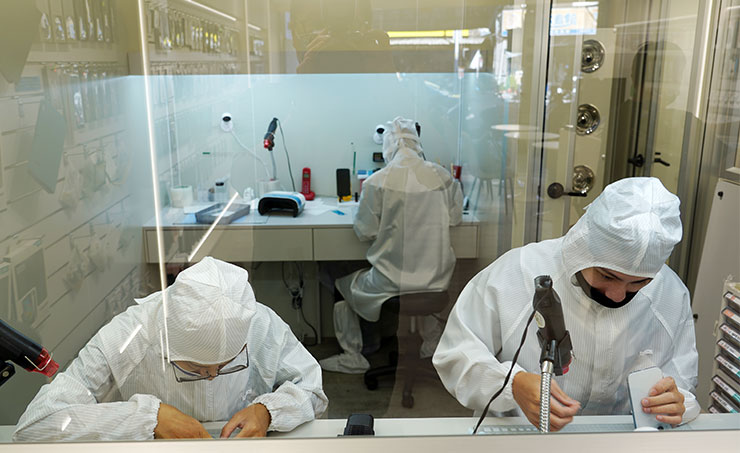 目前無塵室中也有三名師傅同時上工，不難發現 iPhone 15 系列首賣日的熱門啊！