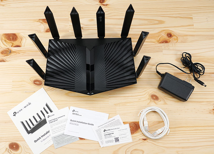 盒內物品一覽，包括 Archer AXE95、說明書 / 快速指引手冊 / 保固說明、供電器與網路線一條。