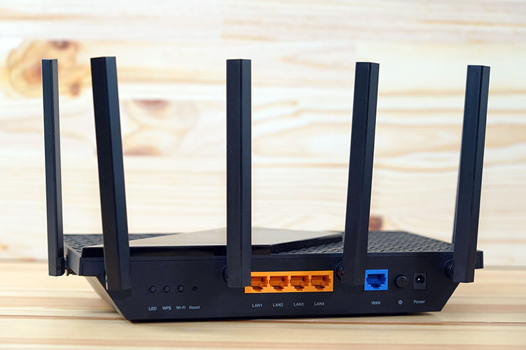 機身後側可看到各類按鈕、4 組 1 Gbps 規格的 LAN 埠與一組 1 Gbps 的 WAN 埠，還有電源按鈕與電源接口。