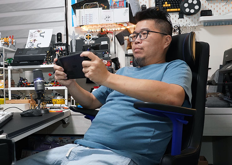 在遊玩掌機如 Steam Deck 時，扶手調至較高位置時，可自然將雙臂向上支撐，讓掌機螢幕符合視線範圍，同時也不需要讓雙手懸空，玩起來更省力！