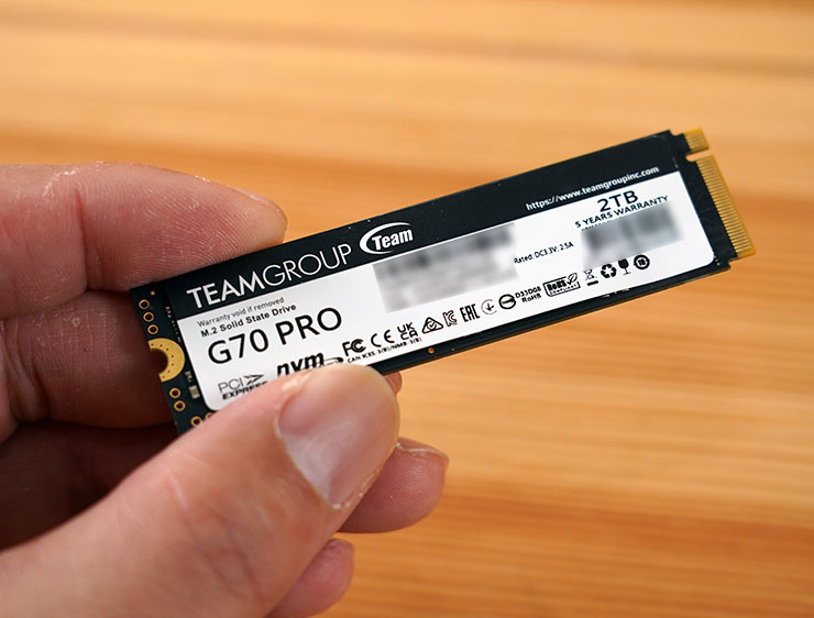 T-Force G70 Pro 背面則為產品標籤貼紙，列出型號、產品序號…等資訊，下方藏有 DRAM 與兩顆 NAND Flash 晶片。