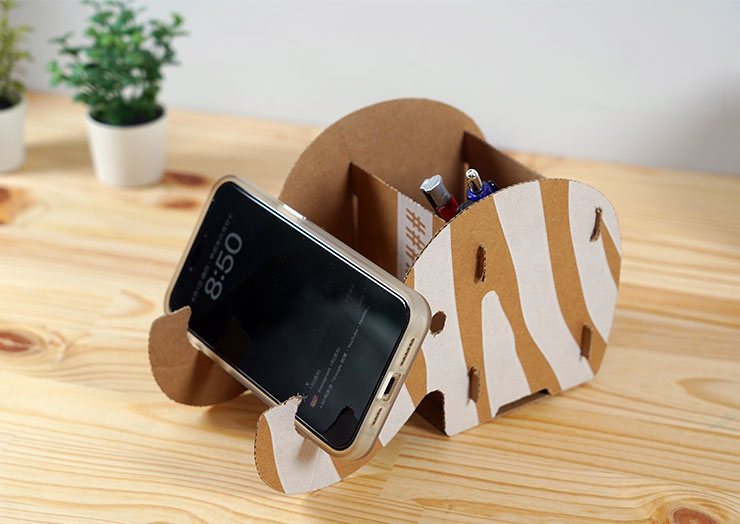 擺飾本身也設計有功能性，除了是筆筒，大象鼻子也能作為手機支架使用。