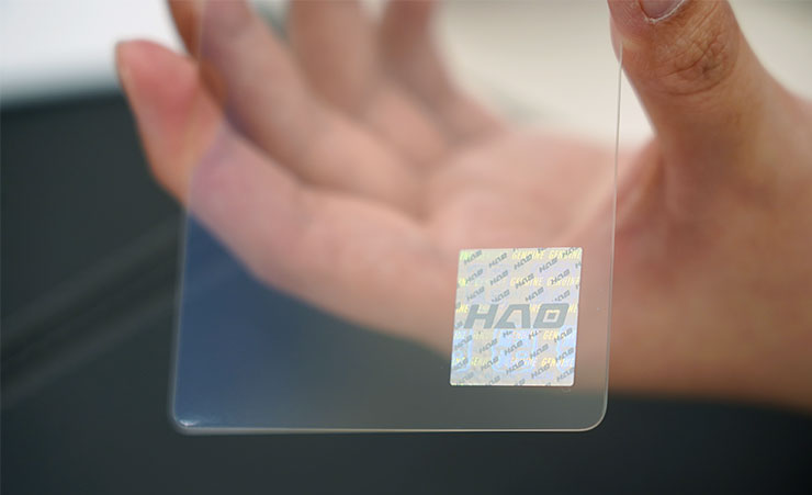 保護貼上可以看到防偽的雷射貼紙，可以看到 HAO 品牌的 LOGO。