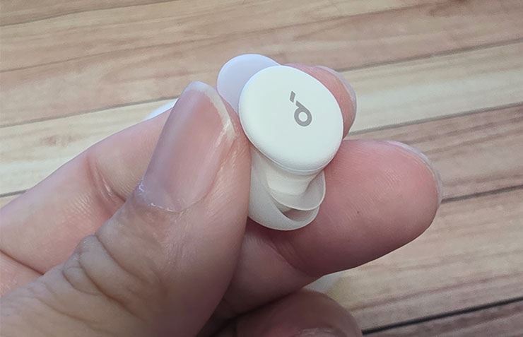 耳機本體非常迷你，外殼可以看到 Soundcore 的 LOGO，同時也附有觸控功能。