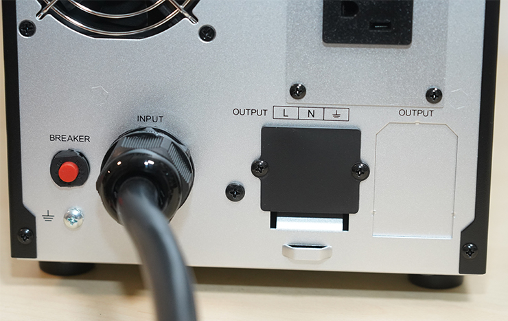 機身後側靠底部處有緊急斷電鈕、電源輸入線與預留的輸出端子台。